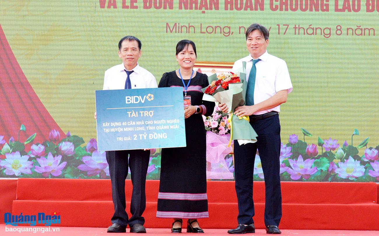 Giám đốc Ngân hàng Thương mại Cổ phần Đầu tư và Phát triển Việt Nam - Chi nhánh Quảng Ngãi Nguyễn Văn Hùng trao bảng tượng trưng tặng 40 căn nhà, tổng trị giá 2 tỷ đồng cho người nghèo huyện Minh Long.